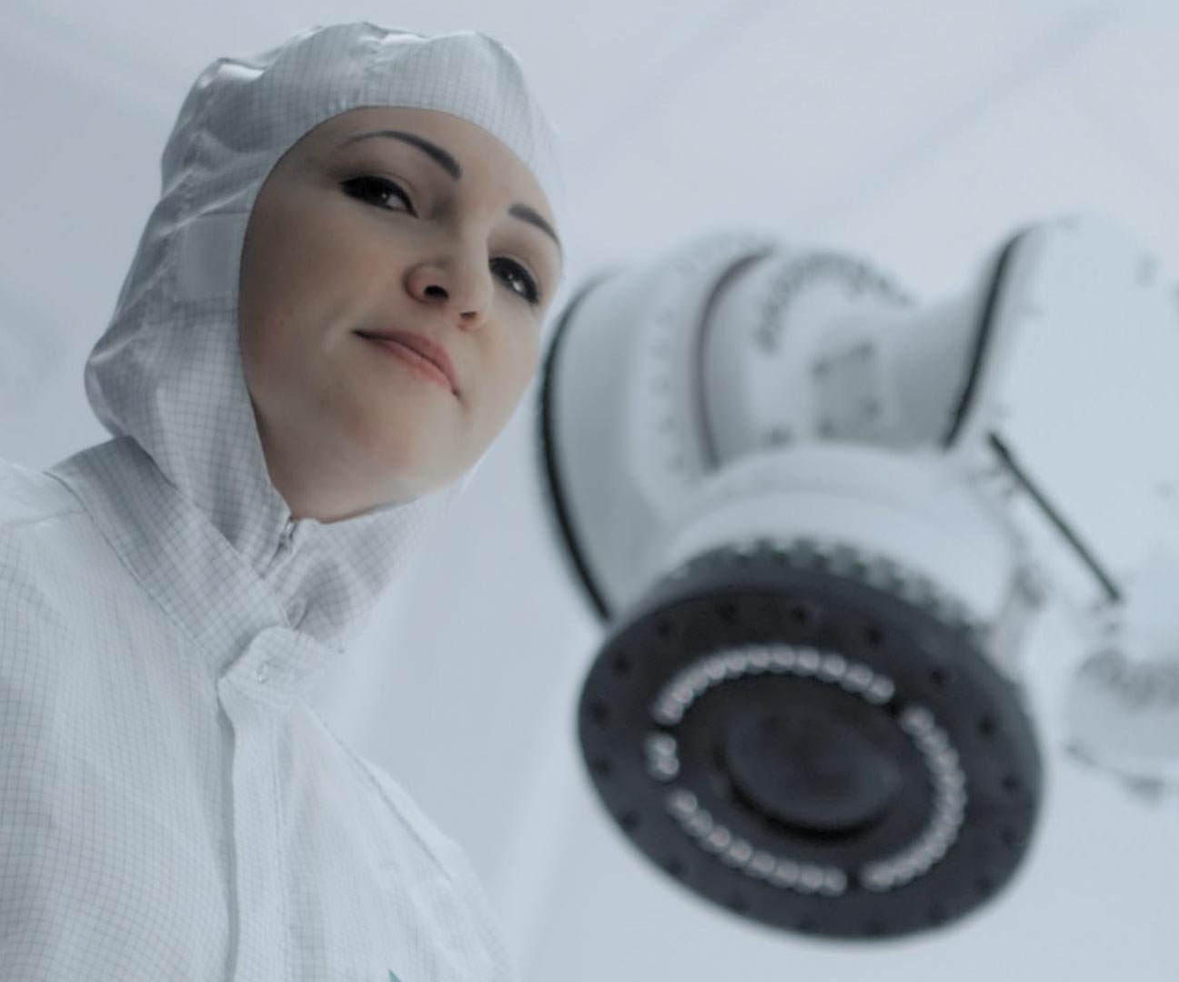 Frau in Schutzanzug vor einer Maschine